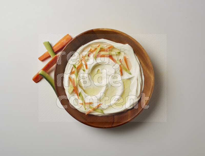 Lebnah garnished with sliced carrots & cucumber in a wooden plate on a white background