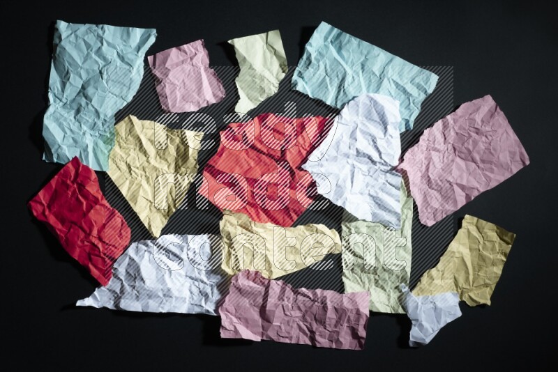 Crumpled multicolored paper on black background