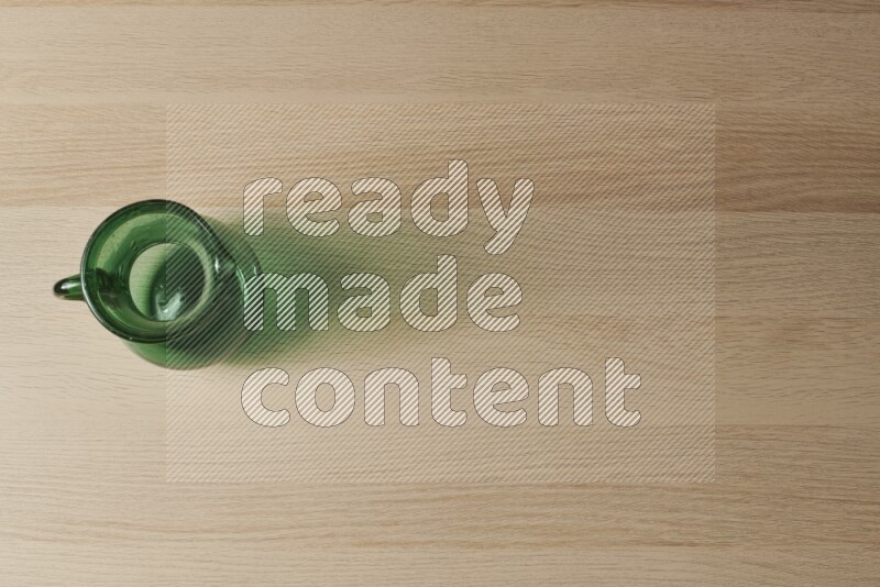 A colored glass jug on light wooden background