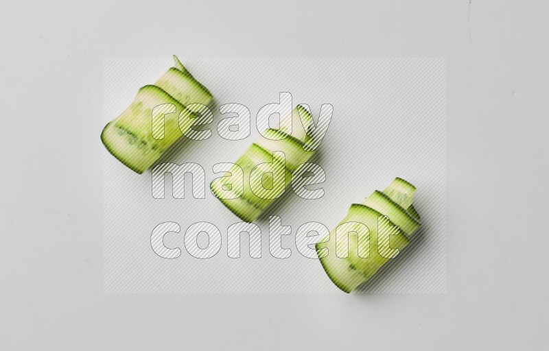 Three cucumber ribbons on a white background