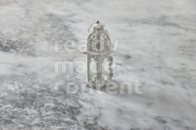 A lantern placed on a grey marble background