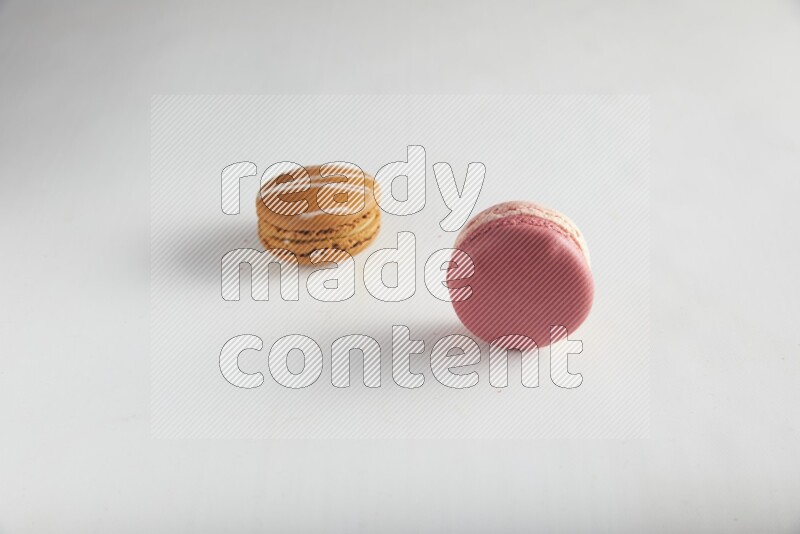 45º Shot of of two assorted Brown Irish Cream, and Pink Litchi Raspberry macarons on white background