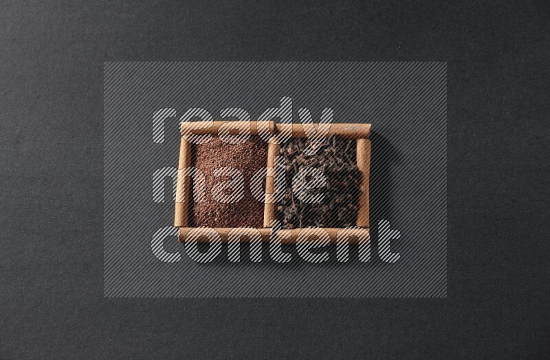 مربعان من أعواد القرفة ممتلئان بحب الرشاد والقرنفل علي خلفية سوداء