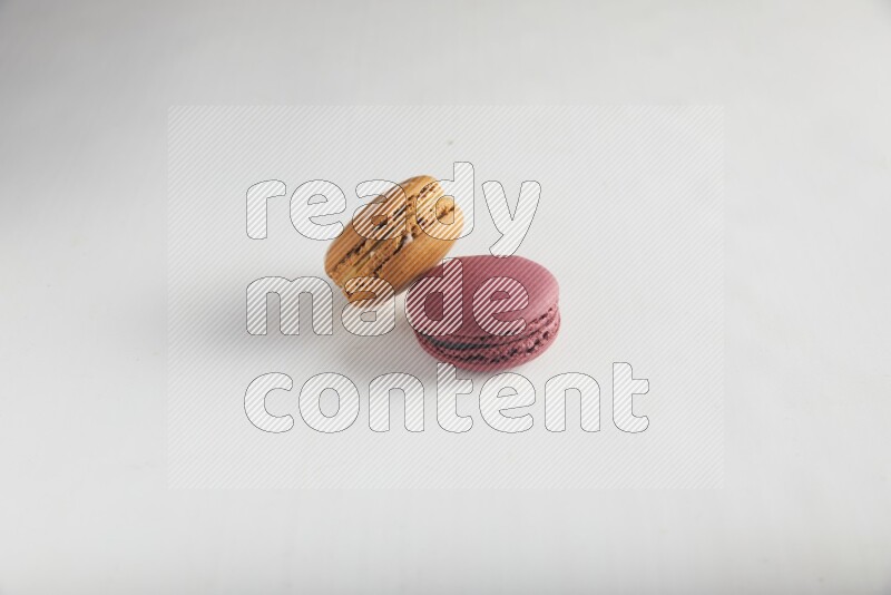 45º Shot of of two assorted Brown Irish Cream, and Red Cherry macarons on white background