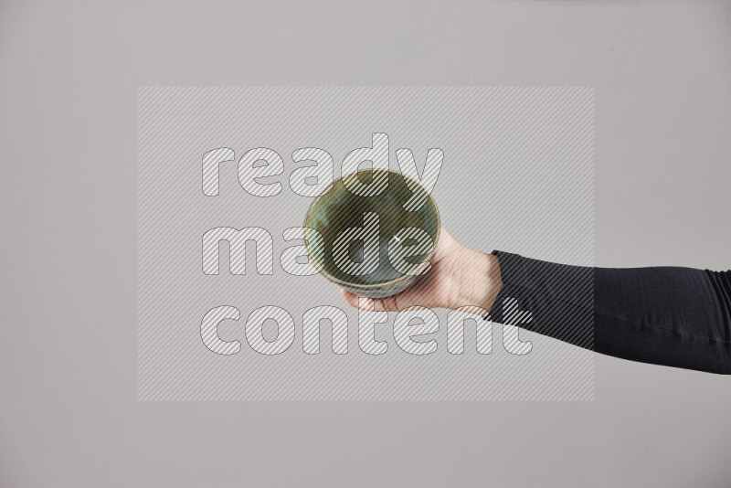 A woman in black abaya holding different pottery essentials in different positions