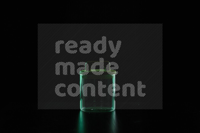 Glassware with rim light in green against black background