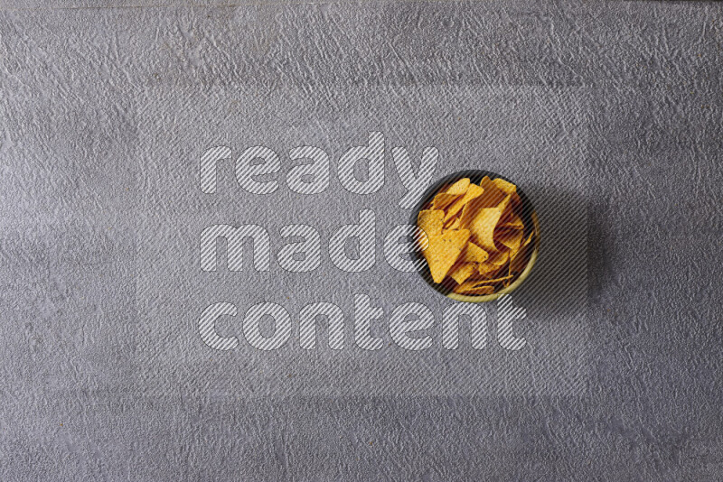 وجبات خفيفة متنوعة في أوعية فخارية على خلفية رمادية