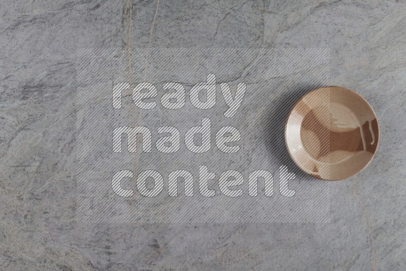 A multicolored pottery plate on grey marble background