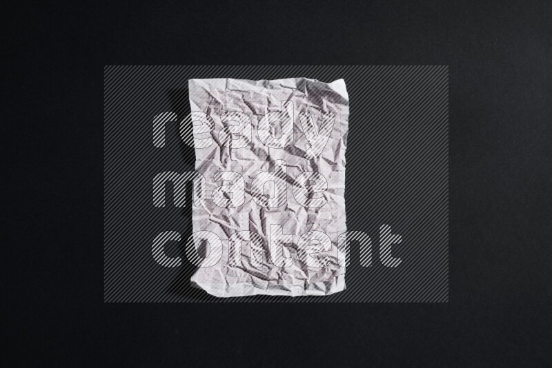 Crumpled notebook sheet on black background