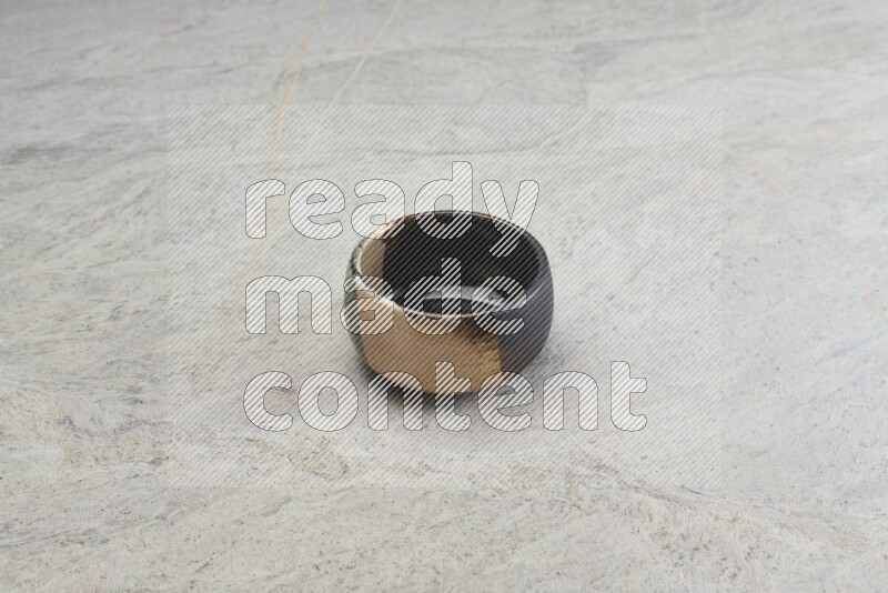 A multicolored pottery bowl on grey marble background