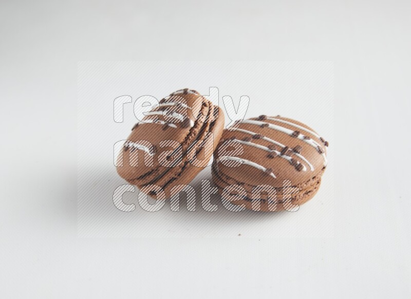 45º Shot of two Brown white Chocolate Caramel macarons on white background