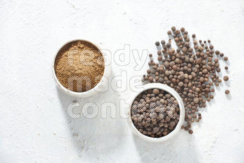 2 beige bowls, one full of powder and the other full of whole balls with balls and powder spreaded on a textured white flooring