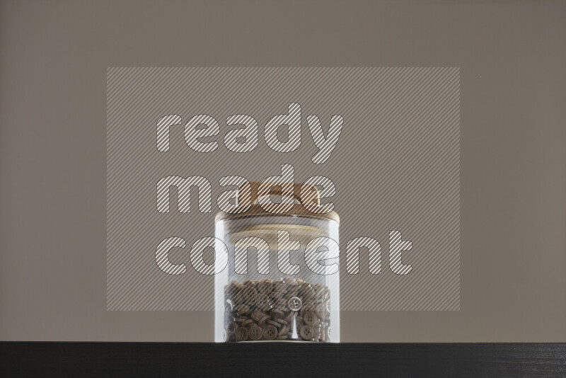 Buttons in a glass jar on black background