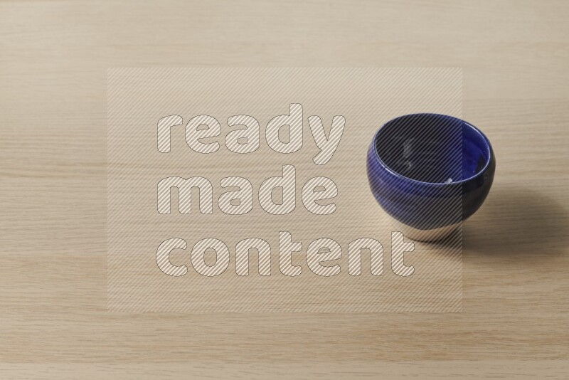 A multicolored pottery bowl on light wooden background