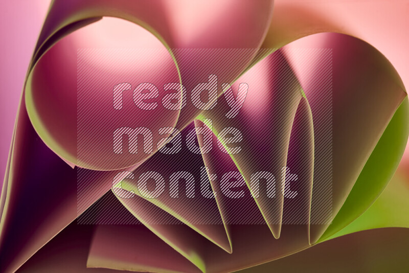 An artistic display of paper folds creating a harmonious blend of geometric shapes, highlighted by soft lighting in green and red tones