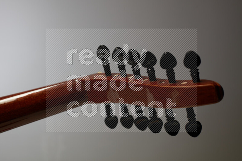 parts of a brown wooden Oud in a gray background