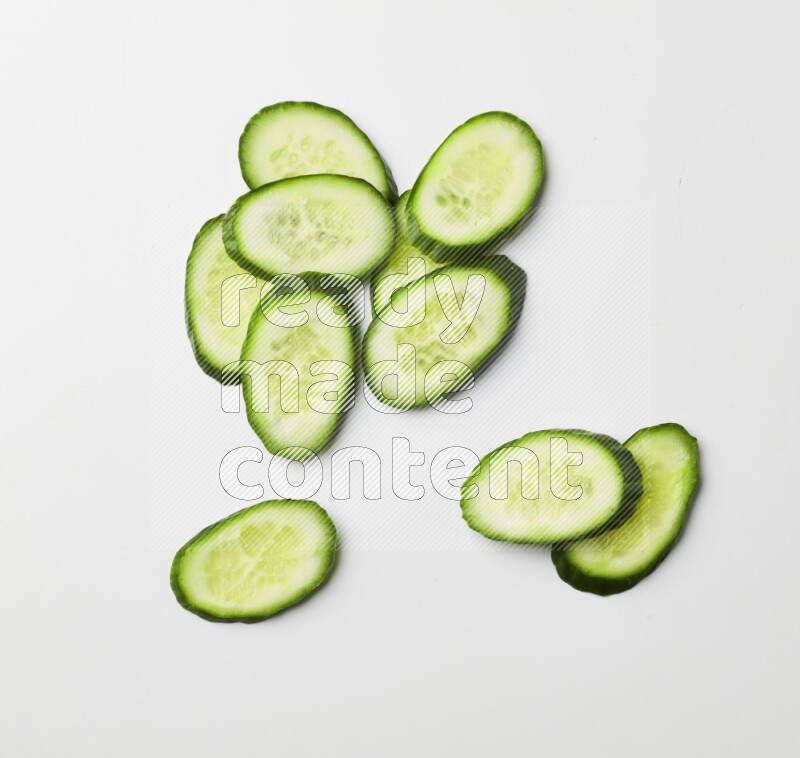 Multiple cucumber slices on white background
