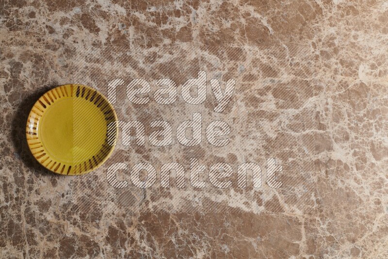 A multicolored pottery plate on beige marble background