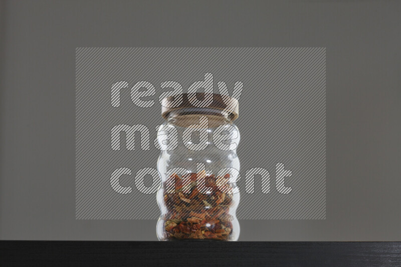 Chili pepper in a glass jar on black background