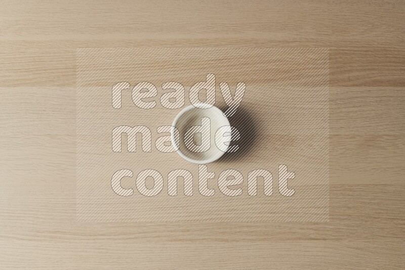 A white pottery bowl on light wooden background