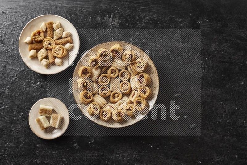 Oriental sweets in pottery plates in a dark setup