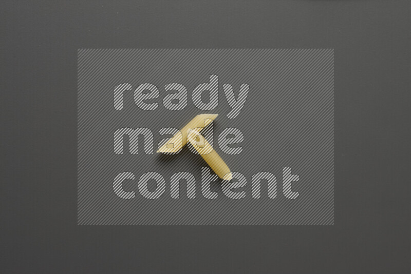 Mini penne pasta on grey background