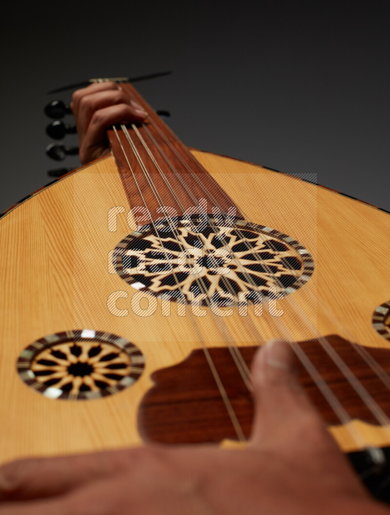 a hand intracting with a wooden brown Oud