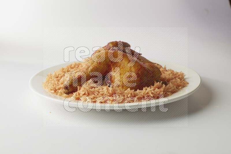 red basmati Rice with kabsa chicken pieces on a white rounded plate direct on white background