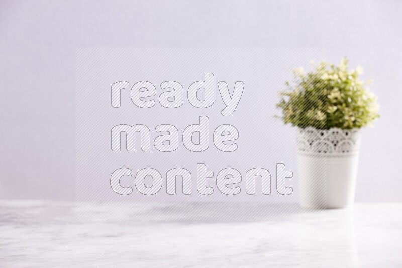 Artificial plant in white decorative pot on grey marble background