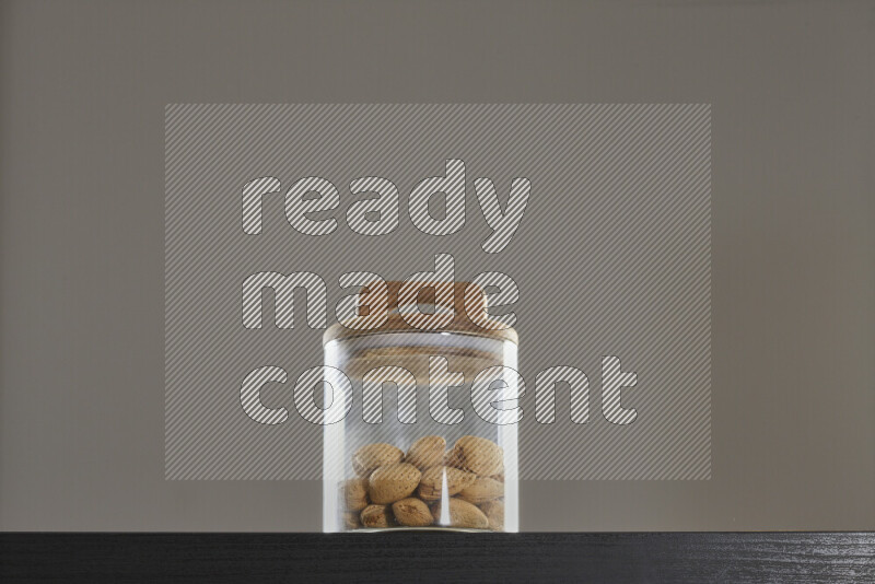 Almonds in a glass jar on black background