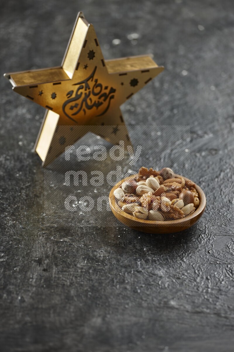 A wooden golden star lantern with different drinks, dates, nuts, prayer beads and quran on textured black background