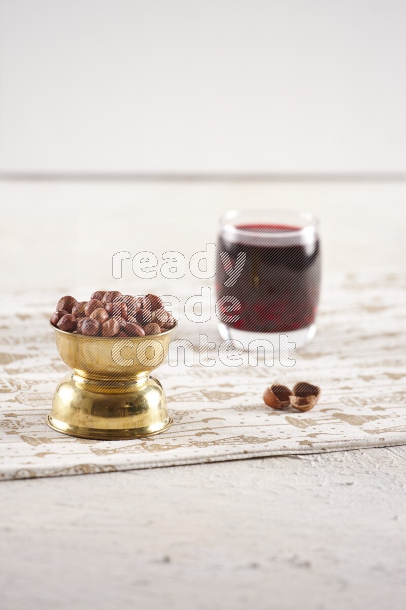 Nuts in a metal bowl with hibiscus in a light setup
