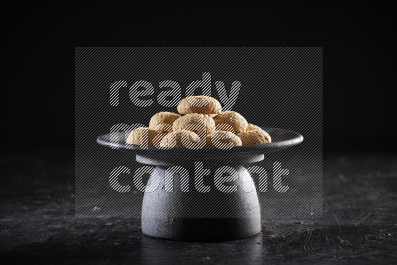 Kahk on a serving plate on a black background