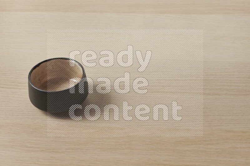 A multicolored pottery bowl on light wooden background