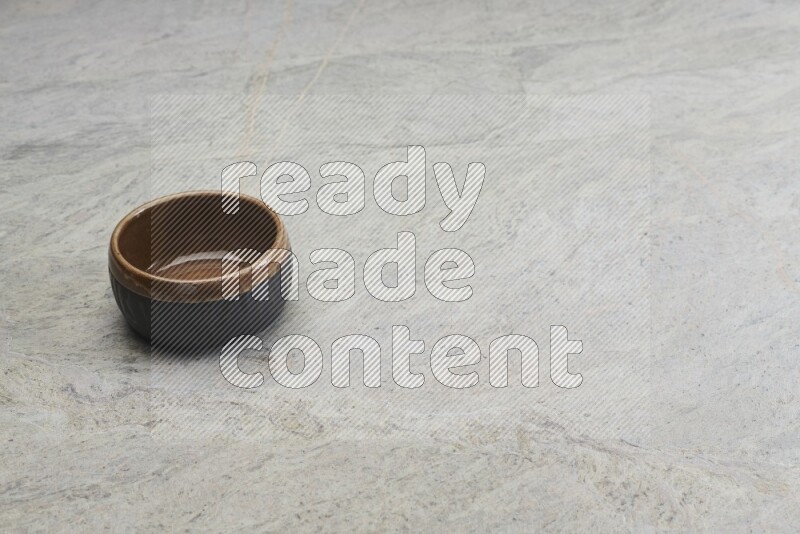 A multicolored pottery bowl on grey marble background