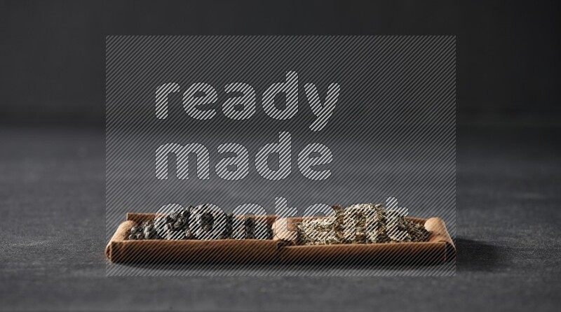 2 squares of cinnamon sticks full of black peppers and cumin on black flooring