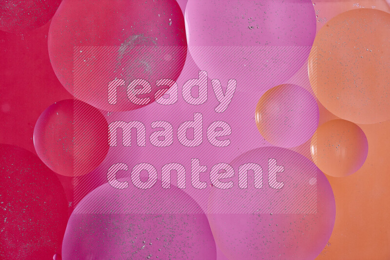 لقطات مقربة لفقاعات من الزيت على سطح الماء باللون الأحمر والبرتقالي والوردي