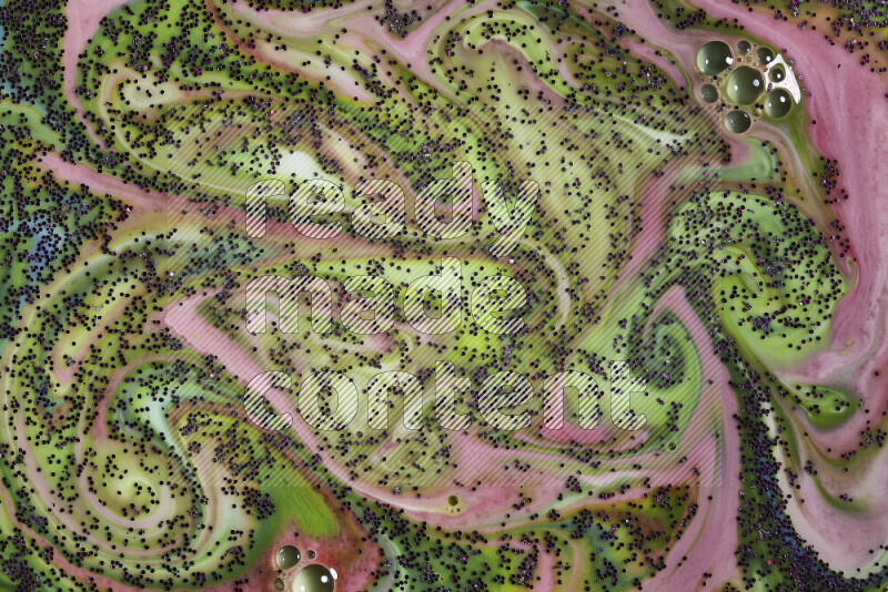 A close-up of sparkling purple glitter scattered on swirling green and red background