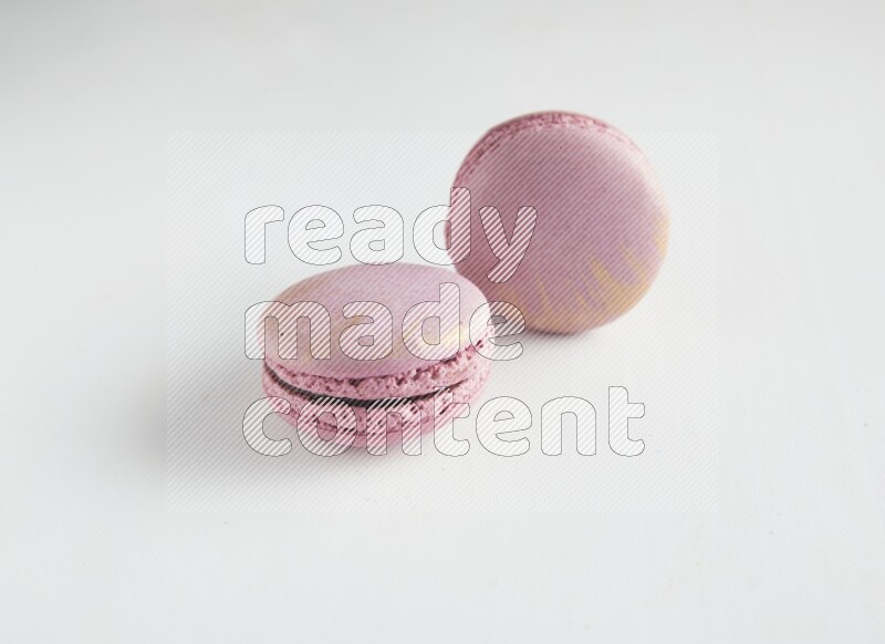 45º Shot of two Purple Strawberry macarons on white background