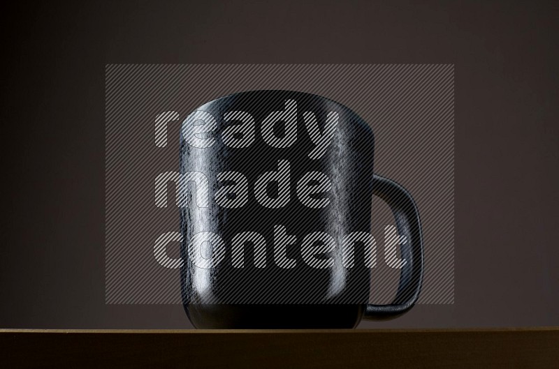 Low angle shot of a black cup on grey background