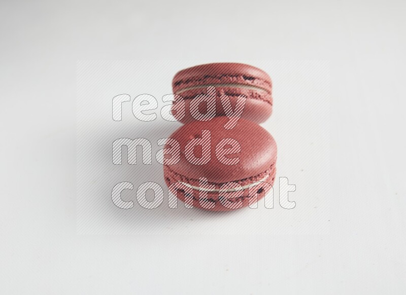 45º Shot of two Red Velvet macarons on white background