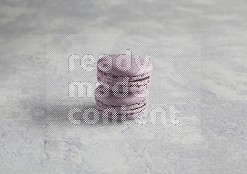 45º Shot of two Purple Blueberry macarons  on white  marble background