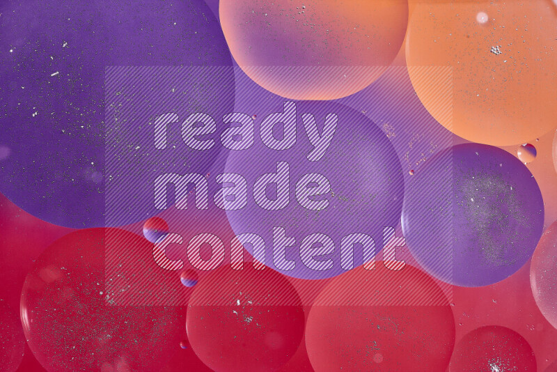 Close-ups of abstract oil bubbles on water surface in shades of red, orange and purple