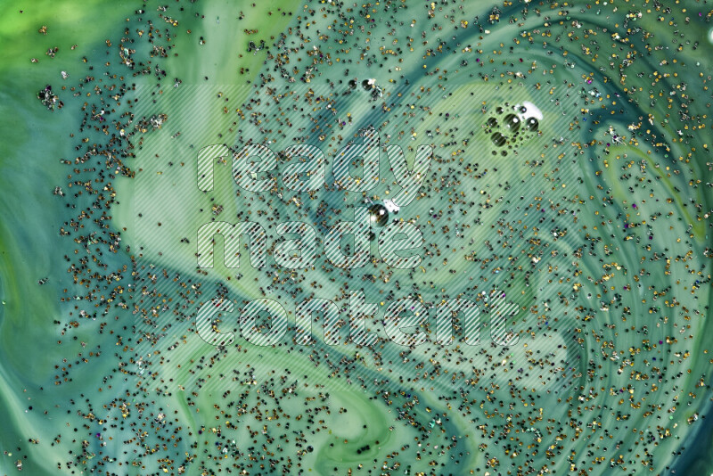 A close-up of sparkling gold glitter scattered on swirling green background