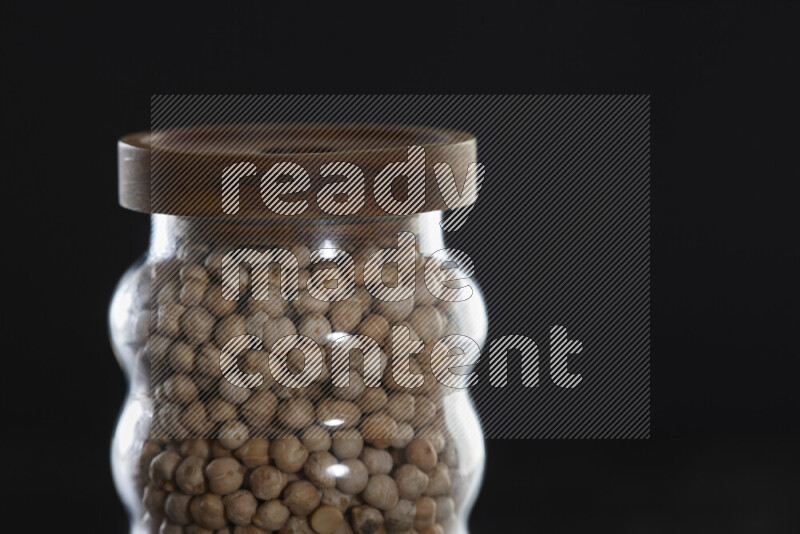 Chickpeas in a glass jar on black background
