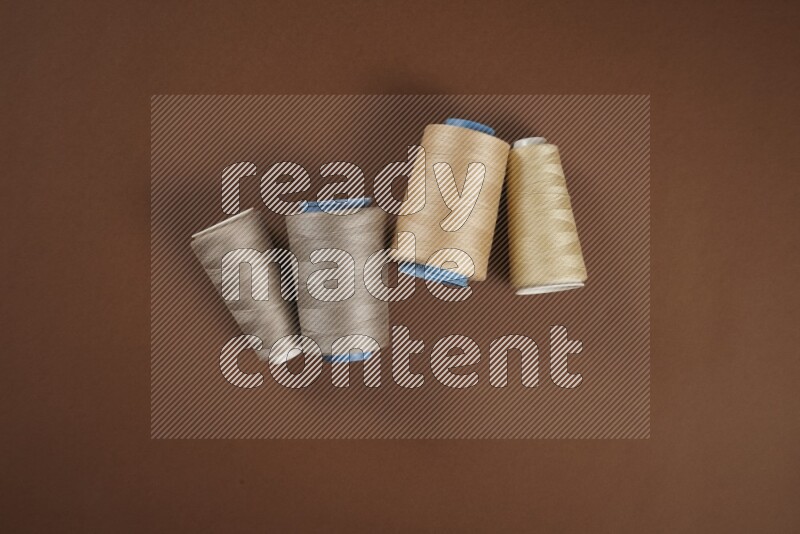 A brown collection of sewing and tailoring tools arranged on a brown background