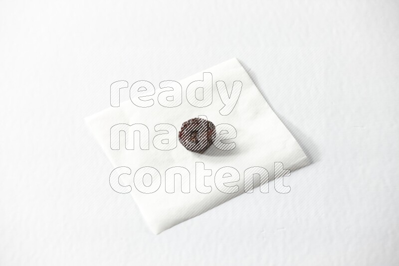 A dried plum on a piece of paper on a white background in different angles