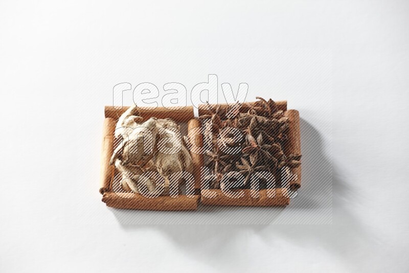 2 squares of cinnamon sticks full of star anise and dried ginger on white flooring