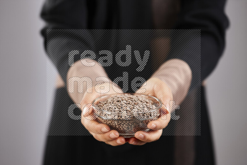 Woman in abaya holding different kinds of legumes in different positions