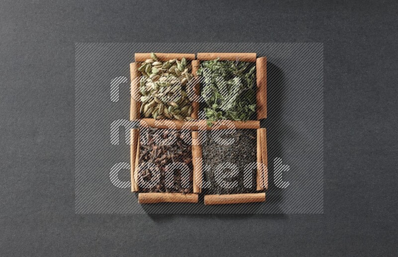 4 squares of cinnamon sticks full of black tea, cloves, dried mint leaves and cardamom on black flooring